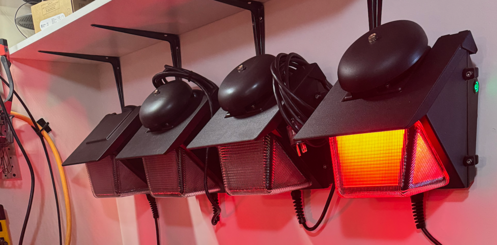 Four PortaBell wall-mounted receiver units on a wall with one unit showing red lights indicating rolling